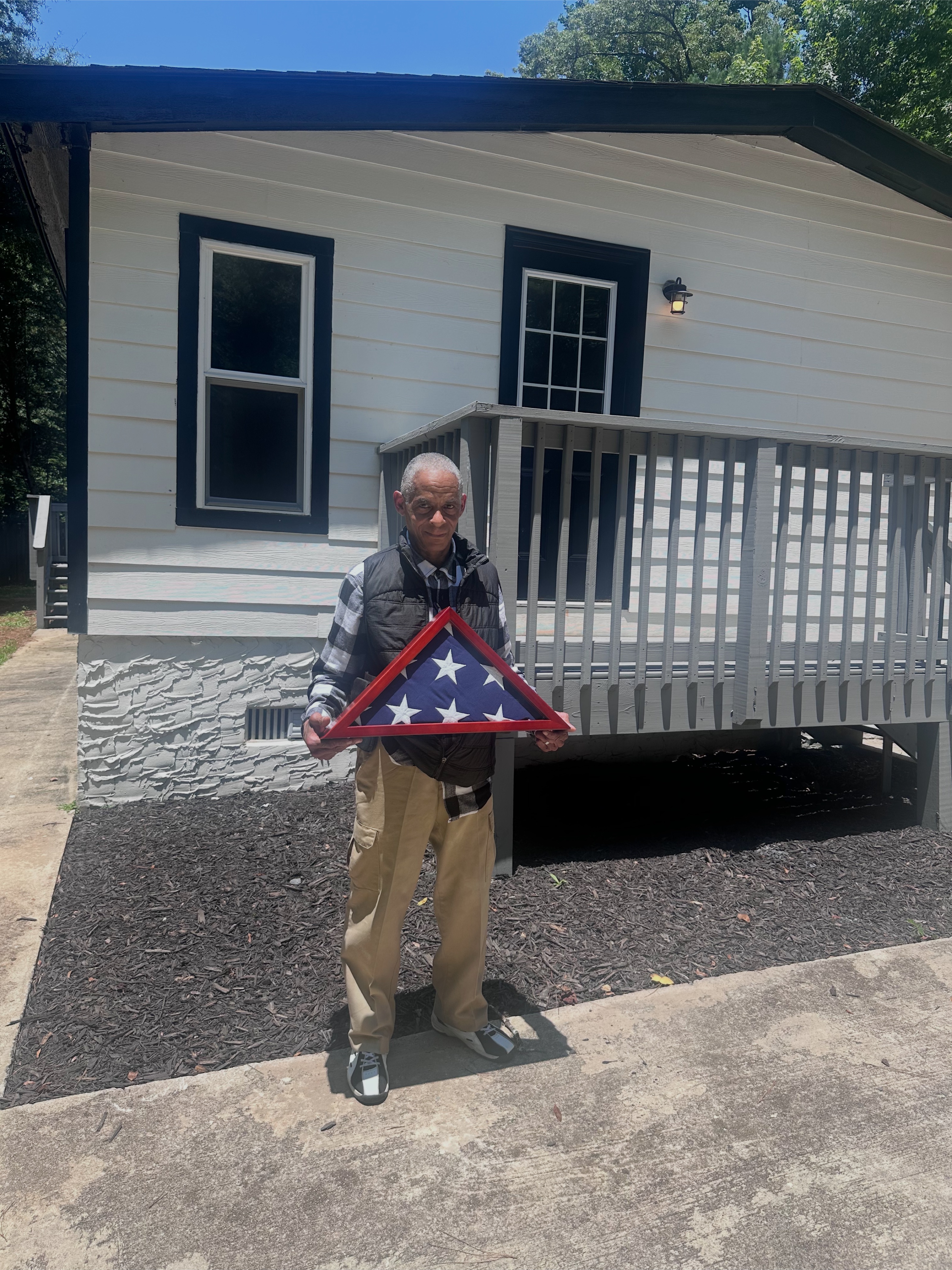 Jacqueline Walker at the lockbox handoff of 350 White Birch Drive in Covington — the buyer, a veteran, arrived with his flag.